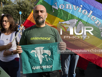 Thousands of people march through Bari, Italy, on October 26, 2024, with banners and flags during a peace rally titled ''Stop the wars, the...