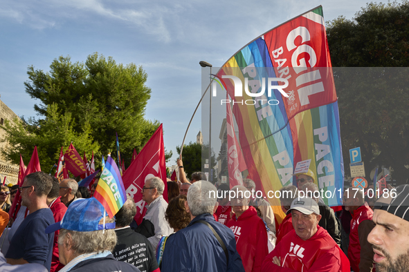 Thousands of people march through Bari, Italy, on October 26, 2024, with banners and flags during a peace rally titled ''Stop the wars, the...