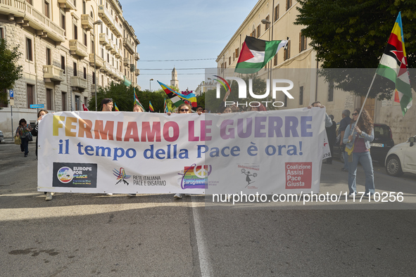 Thousands of people march through Bari, Italy, on October 26, 2024, with banners and flags during a peace rally titled ''Stop the wars, the...