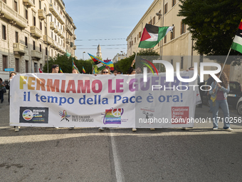 Thousands of people march through Bari, Italy, on October 26, 2024, with banners and flags during a peace rally titled ''Stop the wars, the...