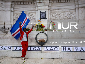 In Lisbon, Portugal, on October 26, 2024, a person holds a flag from Cabo Verde at an improvised memorial at Praca dos Restauradores. They p...