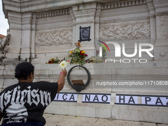 In Lisbon, Portugal, on October 26, 2024, a person holds flowers at an improvised memorial at Praca dos Restauradores. They protest the deat...