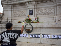 In Lisbon, Portugal, on October 26, 2024, a person holds flowers at an improvised memorial at Praca dos Restauradores. They protest the deat...