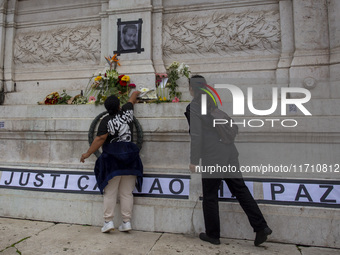 In Lisbon, Portugal, on October 26, 2024, a person holds flowers at an improvised memorial at Praca dos Restauradores. They protest the deat...