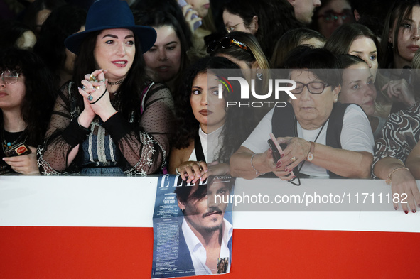 Fans with a Johnny Depp poster wait for the red carpet of the movie ''Modi - Three Days on the Wing of Madness'' during the 19th Internation...