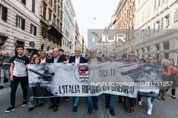 People participate in the demonstration "Italy repudiates war," which is the slogan of the procession that takes place in the streets of Rom...