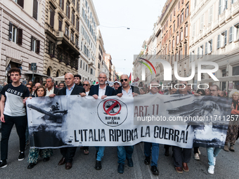 People participate in the demonstration "Italy repudiates war," which is the slogan of the procession that takes place in the streets of Rom...