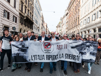 People participate in the demonstration "Italy repudiates war," which is the slogan of the procession that takes place in the streets of Rom...