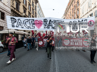 People participate in the demonstration "Italy repudiates war," which is the slogan of the procession that takes place in the streets of Rom...