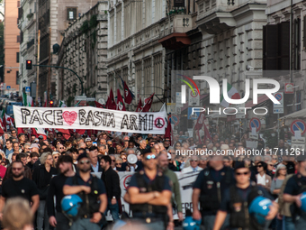 People participate in the demonstration "Italy repudiates war," which is the slogan of the procession that takes place in the streets of Rom...