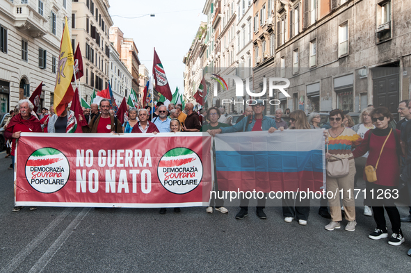 People participate in the demonstration "Italy repudiates war," which is the slogan of the procession that takes place in the streets of Rom...