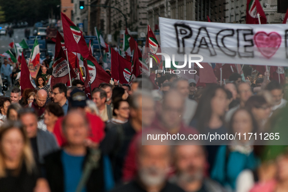 People participate in the demonstration "Italy repudiates war," which is the slogan of the procession that takes place in the streets of Rom...