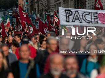 People participate in the demonstration "Italy repudiates war," which is the slogan of the procession that takes place in the streets of Rom...