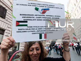 People participate in the demonstration "Italy repudiates war," which is the slogan of the procession that takes place in the streets of Rom...