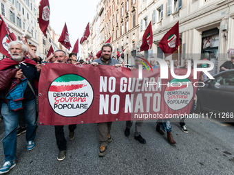 People participate in the demonstration "Italy repudiates war," which is the slogan of the procession that takes place in the streets of Rom...