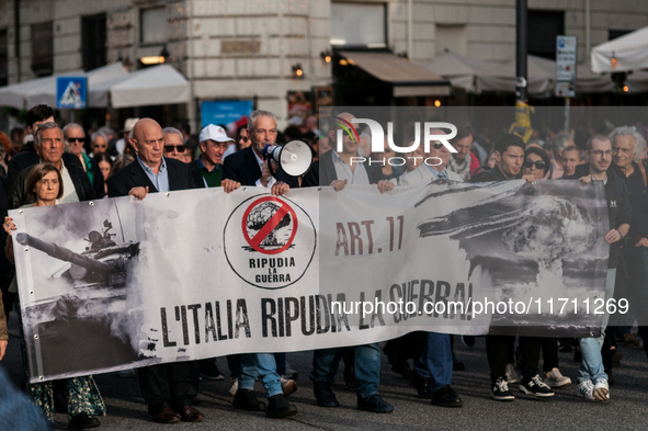 People participate in the demonstration "Italy repudiates war," which is the slogan of the procession that takes place in the streets of Rom...