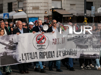 People participate in the demonstration "Italy repudiates war," which is the slogan of the procession that takes place in the streets of Rom...