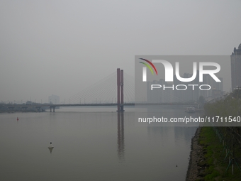 A photo taken on October 26, 2024, shows the bank of the Songhua River under smog in Jilin City, Jilin Province, China. (