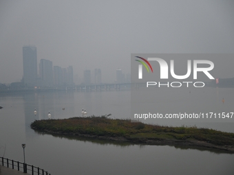 A photo taken on October 26, 2024, shows the bank of the Songhua River under smog in Jilin City, Jilin Province, China. (