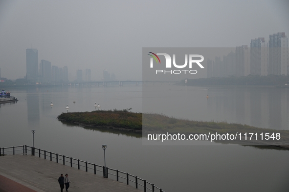 A photo taken on October 26, 2024, shows the bank of the Songhua River under smog in Jilin City, Jilin Province, China. 