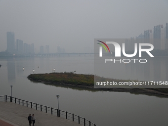 A photo taken on October 26, 2024, shows the bank of the Songhua River under smog in Jilin City, Jilin Province, China. (