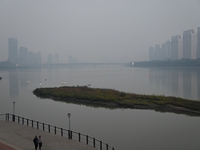 A photo taken on October 26, 2024, shows the bank of the Songhua River under smog in Jilin City, Jilin Province, China. (