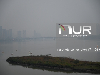 A photo taken on October 26, 2024, shows the bank of the Songhua River under smog in Jilin City, Jilin Province, China. (