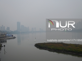 A photo taken on October 26, 2024, shows the bank of the Songhua River under smog in Jilin City, Jilin Province, China. (