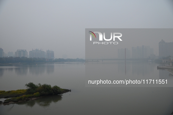 A photo taken on October 26, 2024, shows the bank of the Songhua River under smog in Jilin City, Jilin Province, China. 