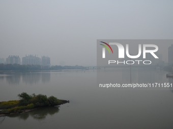 A photo taken on October 26, 2024, shows the bank of the Songhua River under smog in Jilin City, Jilin Province, China. (