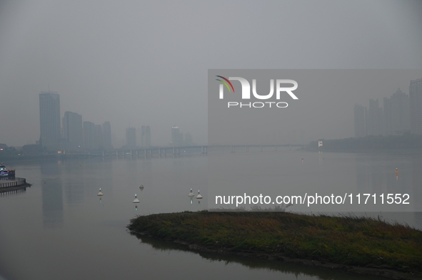 A photo taken on October 26, 2024, shows the bank of the Songhua River under smog in Jilin City, Jilin Province, China. 