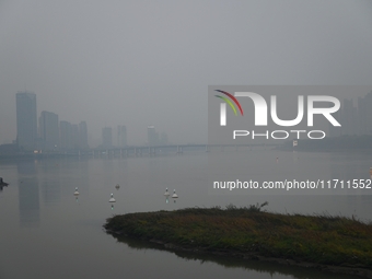 A photo taken on October 26, 2024, shows the bank of the Songhua River under smog in Jilin City, Jilin Province, China. (