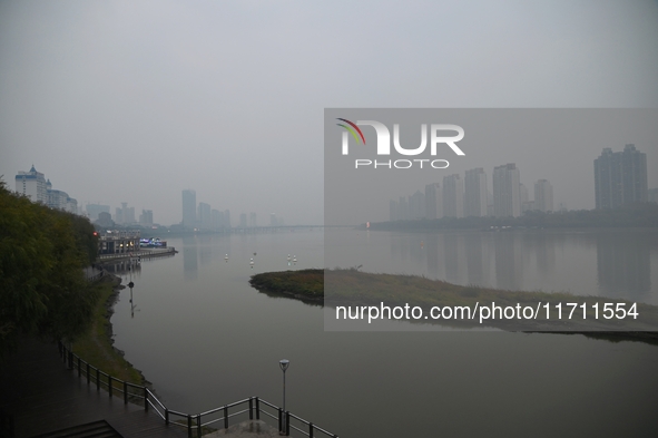 A photo taken on October 26, 2024, shows the bank of the Songhua River under smog in Jilin City, Jilin Province, China. 