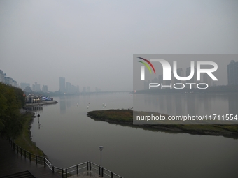 A photo taken on October 26, 2024, shows the bank of the Songhua River under smog in Jilin City, Jilin Province, China. (