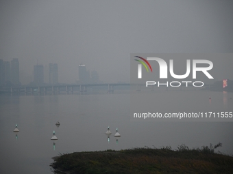 A photo taken on October 26, 2024, shows the bank of the Songhua River under smog in Jilin City, Jilin Province, China. (