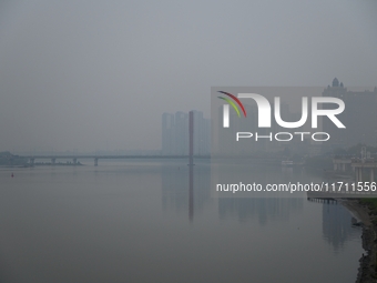 A photo taken on October 26, 2024, shows the bank of the Songhua River under smog in Jilin City, Jilin Province, China. (