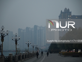 A photo taken on October 26, 2024, shows the bank of the Songhua River under smog in Jilin City, Jilin Province, China. (