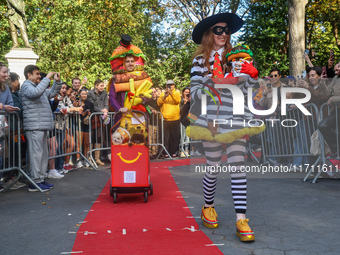 A couple dresses as McDonald's characters with a cart filled with Pomeranians dressed as hamburgers and french fries and poses for a photo d...