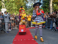 A couple dresses as McDonald's characters with a cart filled with Pomeranians dressed as hamburgers and french fries and poses for a photo d...