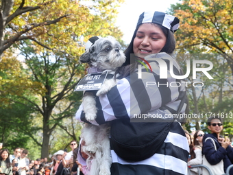 A dog and its owner dress as old-time prisoners and walk the red carpet during the Washington Square Park Halloween Dog Parade in New York,...