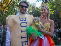 A couple and their dog dress as popcorn and butter for the Washington Square Park Halloween Dog Parade in New York, N.Y., on October 26, 202...