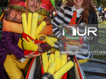 A couple dresses as McDonald's characters with a cart filled with Pomeranians dressed as hamburgers and french fries and poses for a photo d...