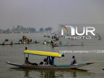 Kashmiri women row boats during the traditional women's boat race at Dal Lake in Srinagar, Jammu and Kashmir, on October 27, 2024. The Jammu...