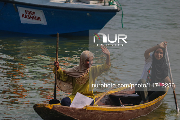 Kashmiri girls react during the traditional women's boat race at Dal Lake in Srinagar, Jammu and Kashmir, on October 27, 2024. The Jammu and...