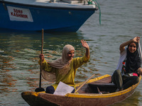 Kashmiri girls react during the traditional women's boat race at Dal Lake in Srinagar, Jammu and Kashmir, on October 27, 2024. The Jammu and...