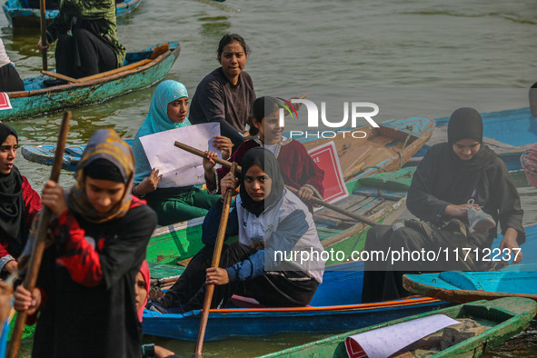 Kashmiri women row boats during the traditional women's boat race at Dal Lake in Srinagar, Jammu and Kashmir, on October 27, 2024. The Jammu...