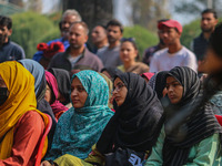 An Indian policeman stands guard as Kashmiri girls look on during the traditional women's boat race in Srinagar, Jammu and Kashmir, on Octob...