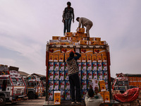 Workers load apple boxes onto trucks, which are sent to different parts of the country from Asia's largest fruit market in Sopore, Jammu and...