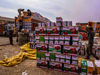 Workers load apple boxes onto trucks, which are sent to different parts of the country from Asia's largest fruit market in Sopore, Jammu and...