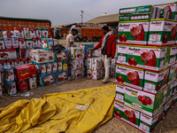 Workers load apple boxes onto trucks, which are sent to different parts of the country from Asia's largest fruit market in Sopore, Jammu and...